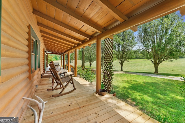 deck with covered porch and a yard