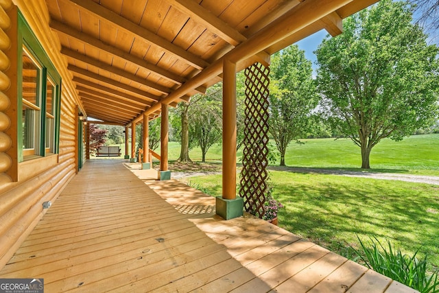 wooden terrace featuring a yard