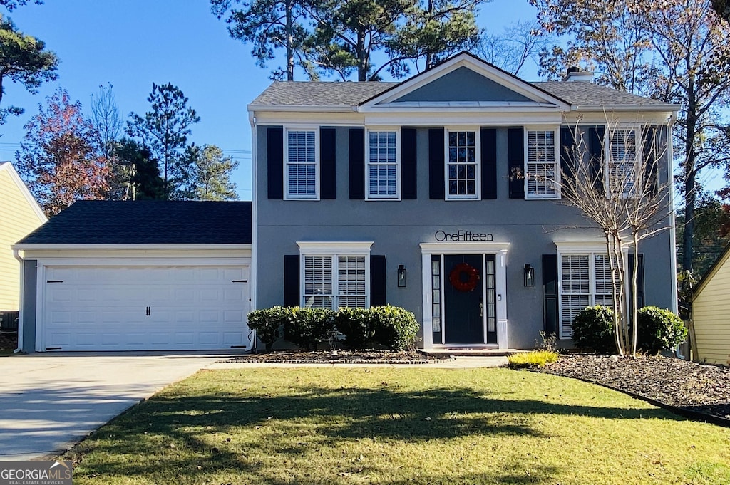 view of front of property featuring a garage and a front lawn