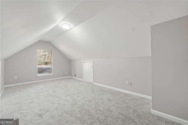 bonus room with carpet floors and vaulted ceiling