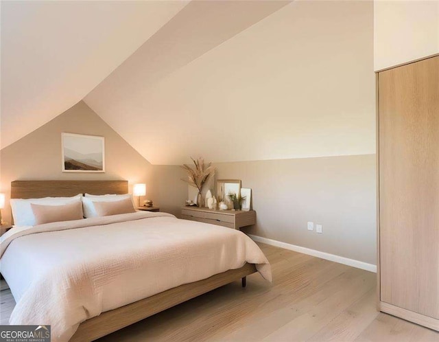 bedroom featuring wood-type flooring and vaulted ceiling