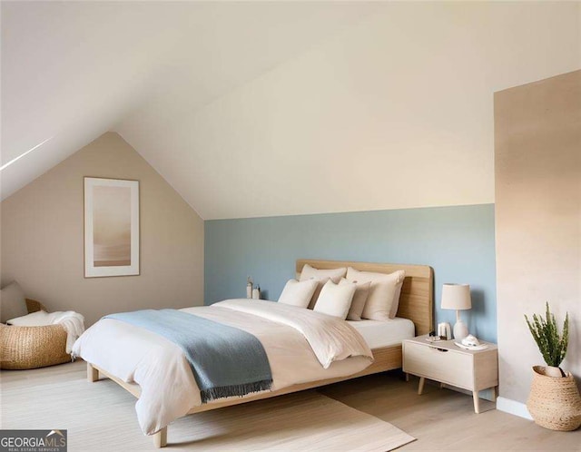 bedroom with wood-type flooring and vaulted ceiling