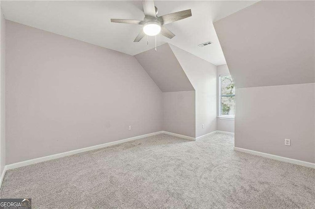 additional living space featuring light carpet, ceiling fan, and lofted ceiling