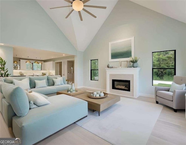 living room featuring ceiling fan, high vaulted ceiling, and light wood-type flooring