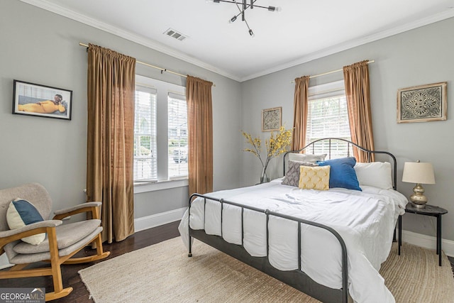 bedroom featuring dark hardwood / wood-style flooring, an inviting chandelier, and ornamental molding