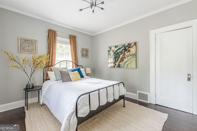 bedroom featuring crown molding, dark hardwood / wood-style flooring, and a notable chandelier