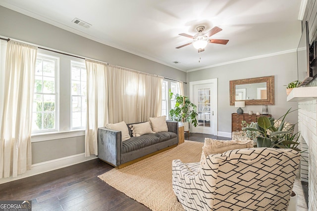 living room featuring dark hardwood / wood-style floors, ceiling fan, ornamental molding, and a brick fireplace