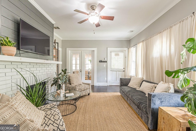 living room with ceiling fan, french doors, a brick fireplace, wood-type flooring, and ornamental molding