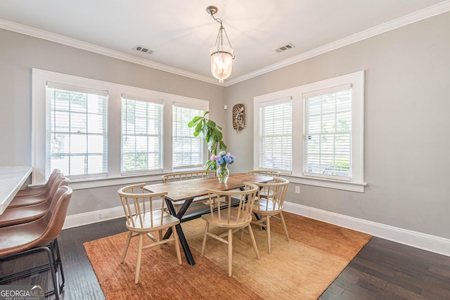 dining room featuring dark hardwood / wood-style floors, crown molding, and a chandelier