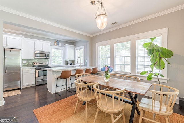 dining room featuring dark hardwood / wood-style floors, ornamental molding, and sink