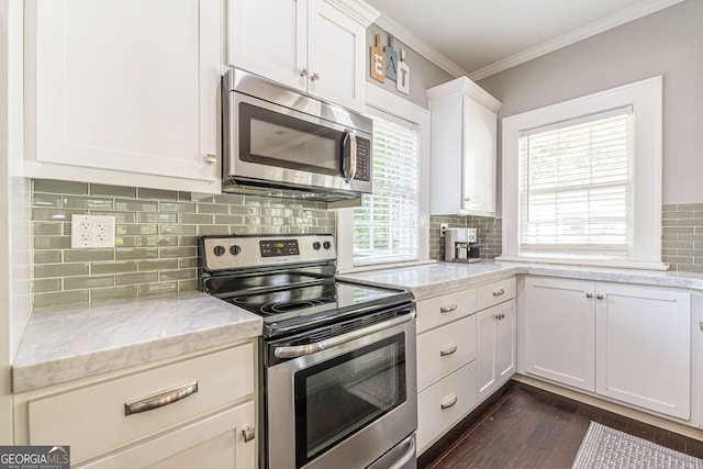 kitchen featuring light stone countertops, white cabinetry, a healthy amount of sunlight, and appliances with stainless steel finishes