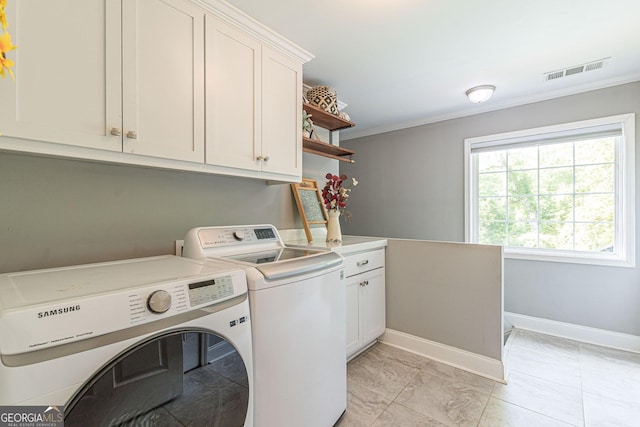 laundry room featuring cabinets, washer and clothes dryer, ornamental molding, and light tile patterned flooring