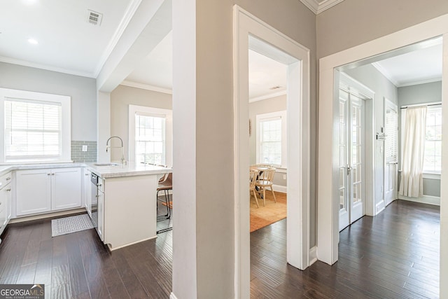 interior space with a healthy amount of sunlight, white cabinetry, kitchen peninsula, and dark wood-type flooring