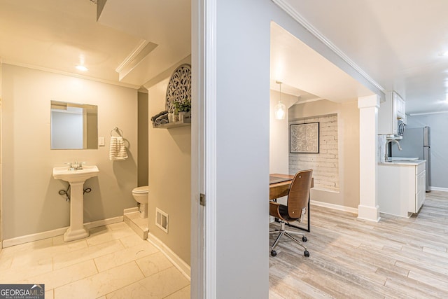 bathroom with hardwood / wood-style floors, toilet, ornamental molding, and sink