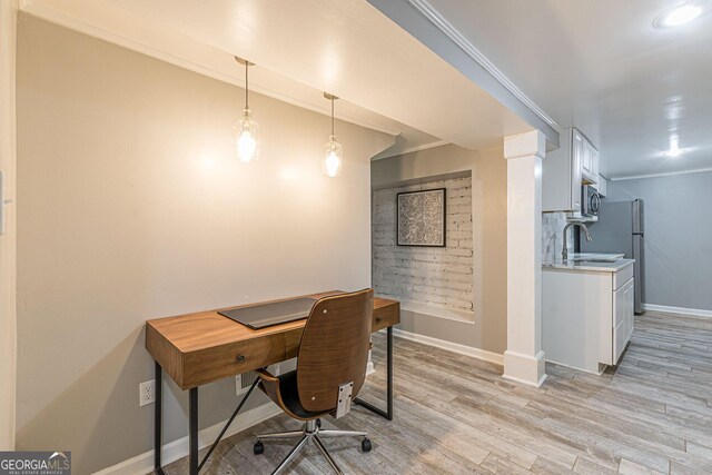 office area featuring crown molding, sink, and light wood-type flooring