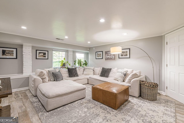 living room featuring crown molding and hardwood / wood-style flooring