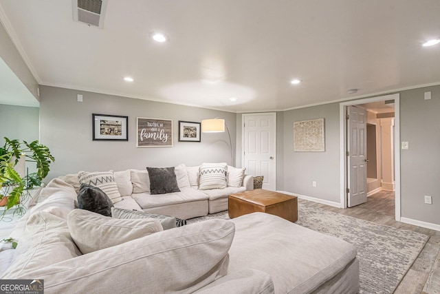 living room with light wood-type flooring and ornamental molding