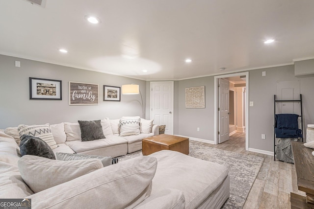 living room with light hardwood / wood-style flooring and crown molding