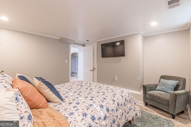 bedroom with crown molding and light hardwood / wood-style floors