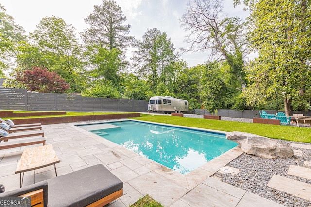 view of swimming pool featuring a patio and a lawn