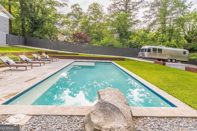 view of pool with a lawn and a patio