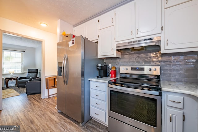 kitchen with decorative backsplash, a textured ceiling, stainless steel appliances, light hardwood / wood-style flooring, and white cabinetry