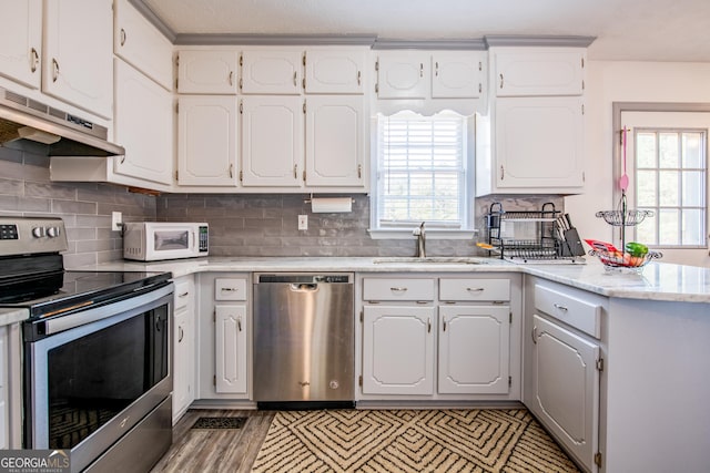 kitchen featuring appliances with stainless steel finishes, white cabinetry, and a healthy amount of sunlight