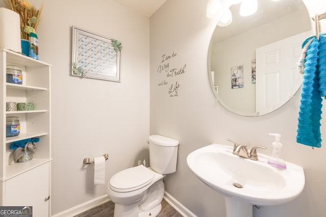 bathroom with wood-type flooring, toilet, and sink