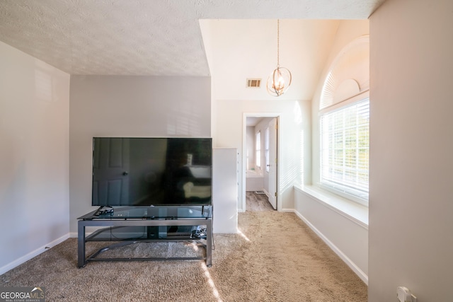 carpeted living room featuring a textured ceiling, lofted ceiling, and a notable chandelier