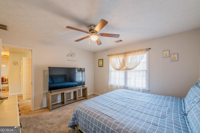 carpeted bedroom featuring a textured ceiling and ceiling fan