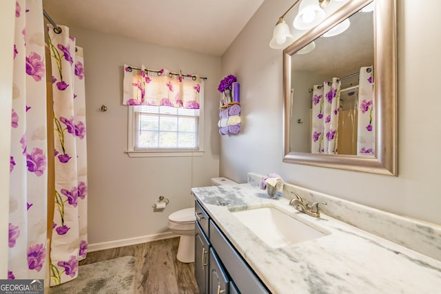 bathroom featuring hardwood / wood-style floors, vanity, curtained shower, and toilet