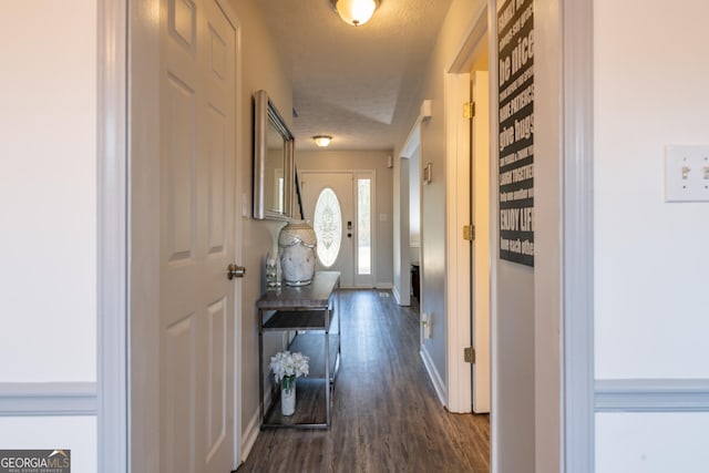 hall featuring dark hardwood / wood-style flooring and a textured ceiling