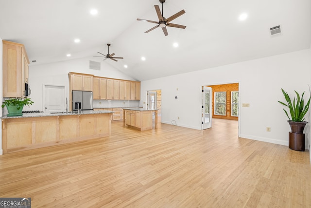 kitchen featuring light stone counters, light brown cabinetry, stainless steel appliances, and light hardwood / wood-style floors