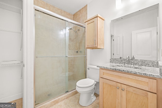 bathroom with tile patterned floors, vanity, toilet, and walk in shower