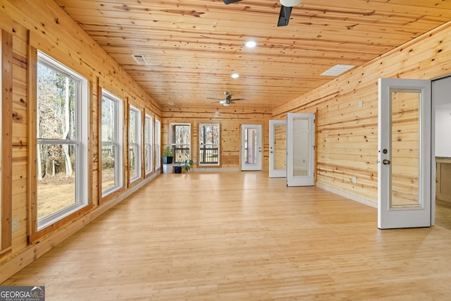 unfurnished sunroom featuring ceiling fan, a healthy amount of sunlight, and wooden ceiling