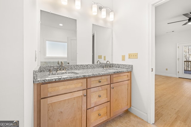 bathroom with hardwood / wood-style floors, ceiling fan, and vanity