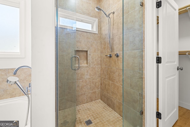 bathroom featuring wood-type flooring and an enclosed shower