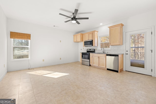 kitchen featuring decorative backsplash, a healthy amount of sunlight, light brown cabinets, and appliances with stainless steel finishes