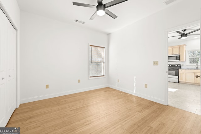 unfurnished bedroom with ceiling fan and light hardwood / wood-style floors