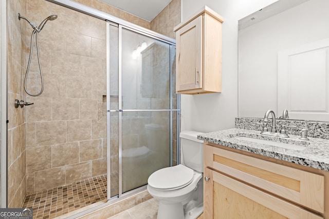 bathroom with tile patterned flooring, vanity, toilet, and a shower with shower door