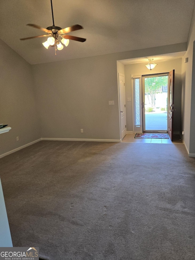 entrance foyer with ceiling fan and carpet