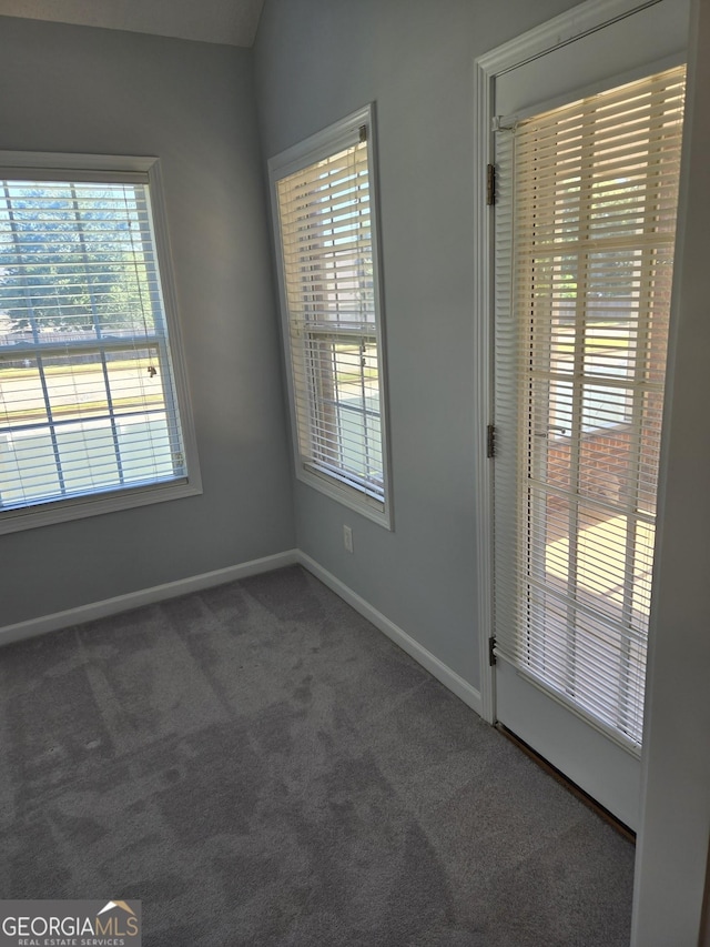 carpeted empty room featuring baseboards