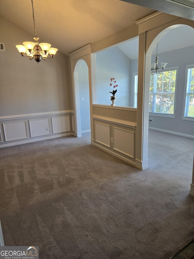 interior space with arched walkways, carpet floors, visible vents, vaulted ceiling, and an inviting chandelier