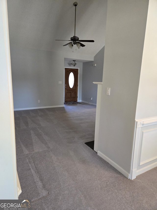 foyer featuring lofted ceiling, carpet, baseboards, and ceiling fan