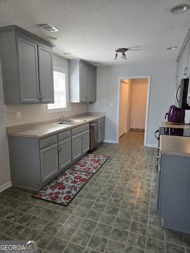 kitchen featuring visible vents, stainless steel appliances, and gray cabinetry