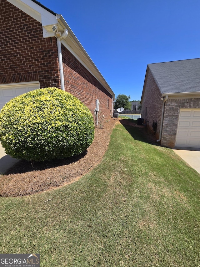 view of side of home with brick siding and a yard