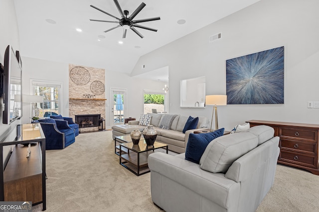 carpeted living room with plenty of natural light, ceiling fan, a fireplace, and high vaulted ceiling