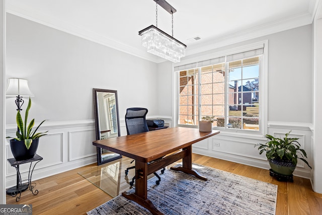 office space featuring crown molding, a chandelier, and light wood-type flooring