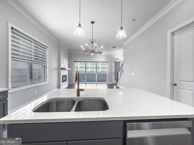 kitchen with a kitchen island with sink, light countertops, and a sink