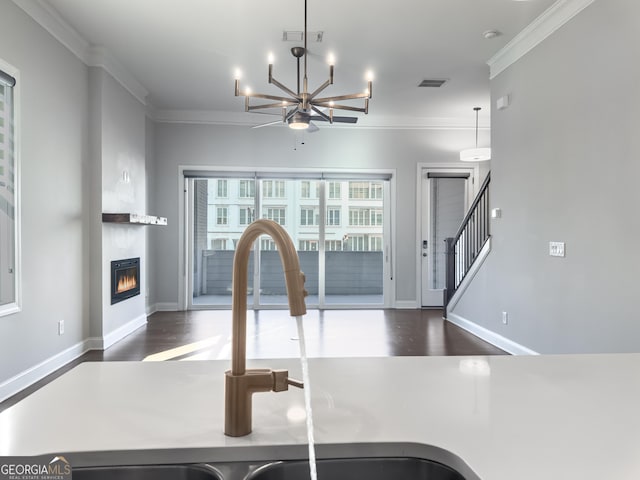 interior space with wood finished floors, a sink, visible vents, and crown molding